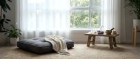 Minimalist living room interior with floor cushion seating, wooden coffee table, and natural light streaming through large windows for modern home decor.