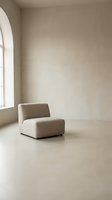 Minimalist beige armchair in empty room with arched window and natural light creating serene modern interior space for home design and architecture.