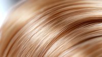 Smooth flowing curves of light brown and beige hair strands create abstract wavy pattern with soft gradient background, suitable for beauty and haircare industry.