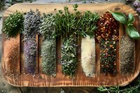 Fresh herbs and colorful spices arranged in rows on rustic wooden board, overhead view perfect for cooking blogs, recipe websites and culinary publications.
