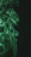 Green smoke swirling against black background, creating abstract flowing patterns. Suitable for design, backgrounds, and creative projects.