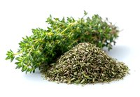 Fresh thyme sprigs and dried herb pile on white background, showcasing culinary ingredient in both forms for cooking and seasoning.