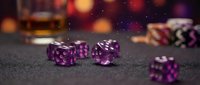 Translucent purple dice on dark surface with bokeh lights and poker chips, suitable for gaming, gambling, entertainment, and casino-related projects.