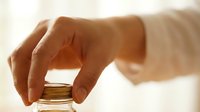 Closeup of hand holding golden glass bottle with dropper cap, isolated on white background for cosmetics, skincare, essential oils, serums, and wellness product packaging design.