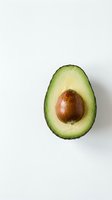 Fresh avocado half with pit on white background isolated for healthy eating and cooking designs.