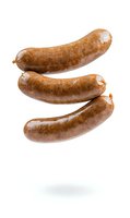 Fresh cooked bratwurst sausages floating on white isolated background with soft shadow. Ready for menu, packaging and food design projects.
