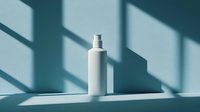 White cosmetic bottle on light blue background with dramatic window shadow casting geometric shapes, minimal product photography for beauty brands.