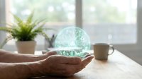 Hands holding glowing digital brain sphere with neural network patterns in bright modern office workspace for artificial intelligence concepts.