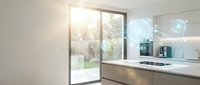 Modern minimalist kitchen interior with sleek cabinets, marble countertops and large glass doors opening to garden patio for contemporary home design.