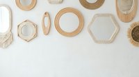 Stylish collection of wooden and wicker mirrors in various geometric shapes arranged on white wall for modern home decor and interior design inspiration.