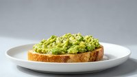 Fresh avocado toast on artisan bread served on white plate, healthy breakfast or lunch meal with creamy green spread and herbs for cafe menu.