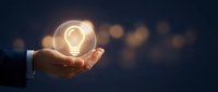 Businessman hand holding glowing light bulb against dark bokeh background representing innovation, creativity, and bright ideas for business solutions.