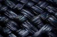 Close up macro shot of black woven carbon fiber material showing detailed texture pattern and glossy surface finish for industrial and tech backgrounds.
