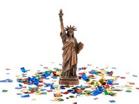 Statue of Liberty monument surrounded by colorful confetti on white background, isolated design element for patriotic celebrations, independence day events, and American themed projects.
