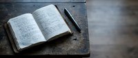 Open vintage notebook with handwritten notes and pen on rustic wooden desk for journaling, writing, education, and creative projects.