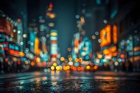 Blurred city street at night with colorful bokeh lights from traffic and buildings creating atmospheric urban scene for backgrounds and design projects.