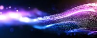 Glowing wave of particles flowing in dark space with purple and blue neon lights creating dynamic motion effect against black background.