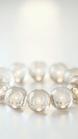 Elegant clear glass spheres with golden glitter sparkles arranged in row on white surface with warm bokeh lights creating festive holiday atmosphere.