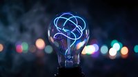 Light bulb with glowing blue brain filament against blurred city lights background representing innovation creativity and intelligent solutions for business.