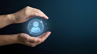 Hands protecting glowing user profile icon symbolizing customer care, data protection and personal information security in digital business environment.