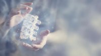 Businessman hands holding glowing puzzle pieces representing teamwork, problem solving and strategic planning in corporate environment with bokeh background.