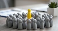 Yellow figure standing out among gray crowd representing leadership, uniqueness, and individual success in business teamwork and personal development.