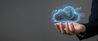 Businessman holding glowing cloud computing hologram with data analytics charts, representing digital transformation and modern technology solutions.