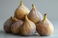 Fresh ripe figs arranged in artistic composition on light background, perfect for food photography, cookbook design, or culinary marketing materials.
