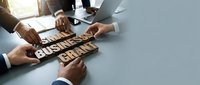 Business team collaboration strategy planning meeting with wooden letter blocks spelling growth on modern office desk.