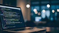 Software developer programming code on laptop screen in modern office environment with bokeh lights creating professional workspace atmosphere.