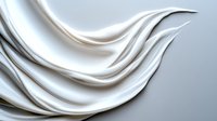 Elegant white silky fabric waves creating smooth flowing curves and gentle folds against light background. Luxurious textile with soft shadows and highlights.