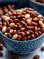 Fresh mixed dried beans in blue ceramic bowl, close-up macro shot showing natural texture and pattern of brown and beige legumes for cooking and food design.
