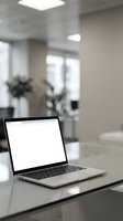 Open laptop with blank white screen on glass desk in modern bright office interior with blurred background for business presentations and workspace mockups.