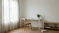 Minimalist home office workspace with wooden chair and white desk near window with natural light, modern interior design for productivity and focus.