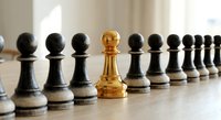 Golden chess pawn standing out among black pawns in row on wooden board. Leadership, uniqueness, strategy and business success concept for presentations.