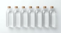 Seven empty glass bottles with cork stoppers arranged in row on white background for packaging design and branding projects.