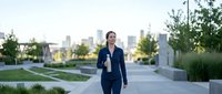 Young athletic woman jogging through modern urban neighborhood during golden hour morning workout routine for healthy active lifestyle fitness.