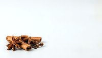 Aromatic cinnamon sticks and star anise spices arranged on clean white background for culinary and cooking projects.