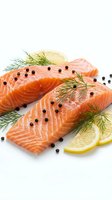 Fresh salmon fillets with dill and lemon slices garnished with black peppercorns on white background for culinary and cooking projects.
