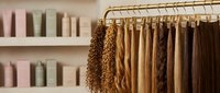 Professional hair extension display showcasing various textures and colors on organized rack for salon beauty treatments and styling services.