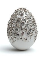 Luxury white Easter egg decorated with sparkling silver rhinestones and crystals on white background for holiday celebrations and elegant decor.
