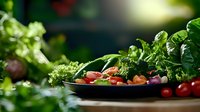 Fresh organic vegetables and herbs on dark plate with vibrant cherry tomatoes and leafy greens in soft natural light for healthy cooking concept.