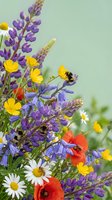 Vibrant wildflower bouquet with purple lupines, yellow buttercups, red poppies, white daisies and bumblebees on soft green background. Perfect for spring designs.