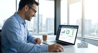 Young professional businessman analyzing financial data and charts on laptop computer in modern office workspace with city view background.