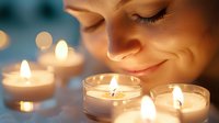 Young woman with gentle smile near glowing candles in glass holders creating cozy atmosphere with soft bokeh lights and warm illumination.