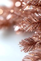 Glittering rose gold Christmas tree branches with sparkling bokeh lights and festive shimmer on white background, macro close-up view for holiday designs.