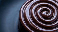 Rich dark chocolate swirl pattern with glossy finish creating elegant spiral design for culinary and dessert themed projects.
