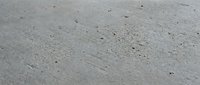 Wet sand beach texture with natural patterns and small shells scattered across smooth surface after wave retreat creating organic coastal background.