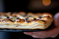 Flaky layers of golden puff pastry with crispy edges shown in close-up macro shot, revealing delicate buttery texture and intricate laminated dough structure.