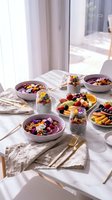 Healthy breakfast spread with acai bowls, chia pudding and fresh fruit on white table in bright morning light for wellness lifestyle content.